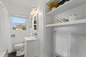 Bathroom with vanity, toilet, and tile walls