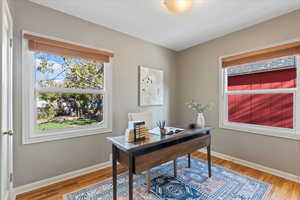 Home office with hardwood / wood-style flooring and a textured ceiling