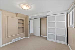 Unfurnished bedroom with light carpet and a closet