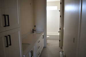 Bathroom with tile patterned floors, vanity, and toilet