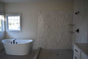 Bathroom with tile patterned flooring, vanity, and separate shower and tub