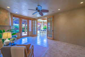 Interior space with a healthy amount of sunlight, light tile patterned flooring, ceiling fan, and french doors