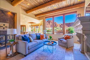 Living room featuring wooden ceiling, beam ceiling, an inviting chandelier, and a mountain view