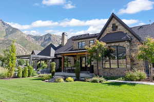 Back of property featuring a lawn and a mountain view