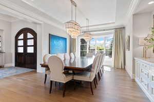 Dining area with crown molding, white oak floors, and a chandelier