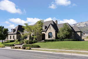 View of front of property with a mountain view and a front yard