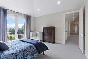 Bedroom featuring light carpet, vaulted ceiling, access to exterior, and french doors