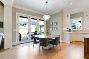 Dining space featuring a notable chandelier, lwhite oak floors, french doors, and plenty of natural light