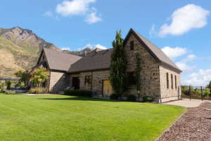 View of side of property featuring a yard and a mountain view