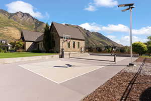 View of sport court featuring a mountain view and a yard