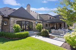 Back of property featuring a lawn, a patio area, and an outdoor hangout area