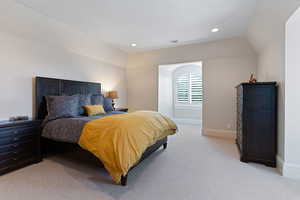 Bedroom with light carpet and vaulted ceiling