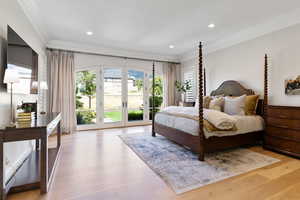 Primary bedroom featuring french doors, white oak floors, crown molding, and access to exterior