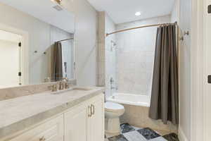 Full bathroom with vanity, toilet, and shower / bath combo with shower curtain