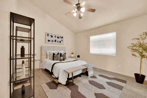 Bedroom featuring carpet flooring, ceiling fan, and vaulted ceiling