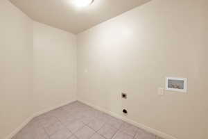 Laundry area featuring electric dryer hookup, light tile patterned floors, and hookup for a washing machine