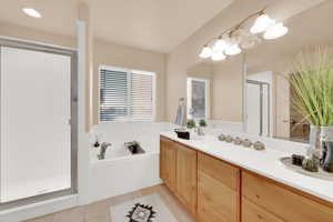 Bathroom with tile patterned flooring, vanity, and separate shower and tub