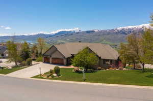 View of front of property with a garage, a front lawn, and a mountain view