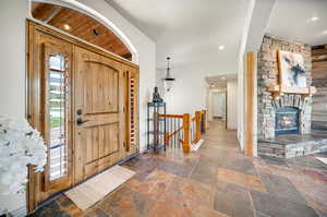 Foyer with wood ceiling and a stone fireplace