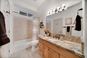 Full bathroom with shower / bath combo with shower curtain, vanity, tile patterned flooring, and toilet