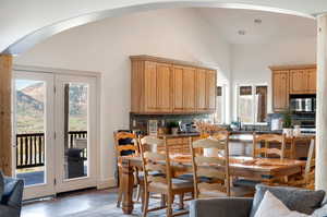 Interior space with a wealth of natural light, lofted ceiling, appliances with stainless steel finishes, and backsplash