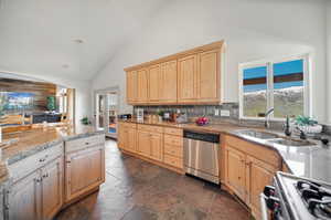 Kitchen with a mountain view, high vaulted ceiling, gas range oven, dishwasher, and light brown cabinetry