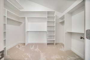 Walk in closet with light colored carpet