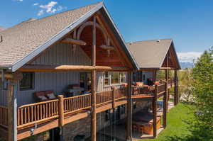 Back of house with a large wrap around wooden deck