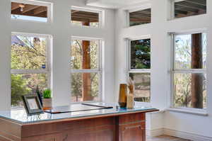 Office/Den featuring a healthy amount of sunlight, lofted ceiling, and light tile patterned floors