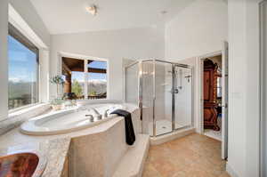 Primary Bathroom with independent shower and bath, tile patterned flooring,  jetted tub, mountain views, and vaulted ceiling