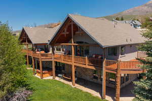 Back of property featuring a wrap around deck, a patio, a Mountain View