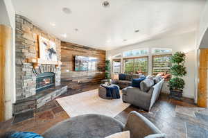 Living room featuring wooden walls and a fireplace