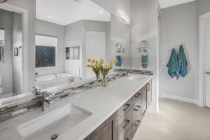 Bathroom with decorative backsplash, a washtub, vanity, and toilet