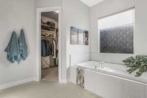 Bathroom with a relaxing tiled tub and tile patterned flooring