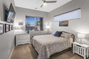 Carpeted bedroom featuring ceiling fan