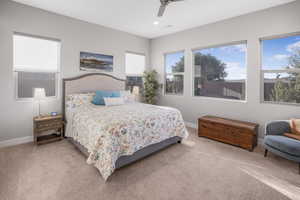 Carpeted bedroom featuring ceiling fan