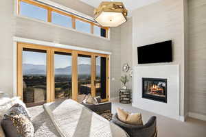 Bedroom featuring access to outside, a high ceiling, a high end fireplace, and a mountain view