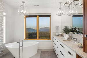 Bathroom featuring a bathtub, vanity, and a mountain view