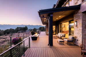 Deck at dusk with a mountain view and an outdoor living space with a fire pit