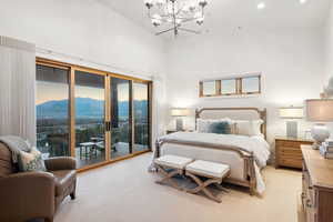 Carpeted bedroom with high vaulted ceiling, a mountain view, a chandelier, and access to exterior