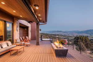 Deck featuring a mountain view and an outdoor living space with a fire pit