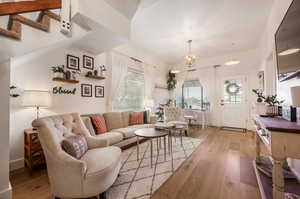 Living room with light wood-type flooring and an inviting chandelier