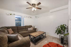 Living room with ceiling fan and light colored carpet