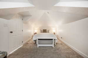 Bedroom featuring carpet floors, a textured ceiling, and lofted ceiling