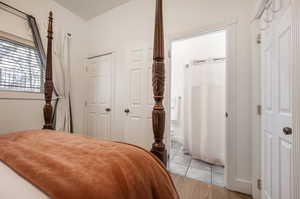 Bedroom with connected bathroom and light hardwood / wood-style flooring