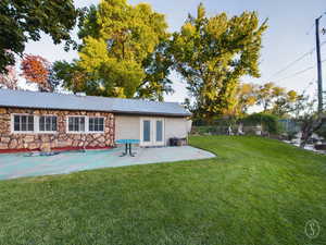 Rear view of property with a patio, french doors, and a yard