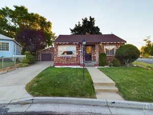 View of front of property featuring a garage and a yard