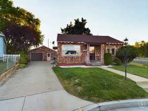 View of front facade featuring a garage and a front lawn