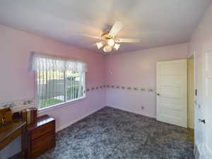 Carpeted spare room featuring ceiling fan and a textured ceiling