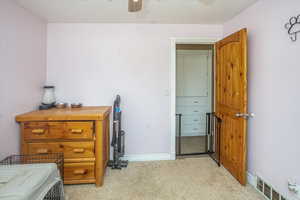 Carpeted bedroom featuring ceiling fan